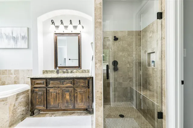 a bathroom with a granite countertop sink a mirror and shower
