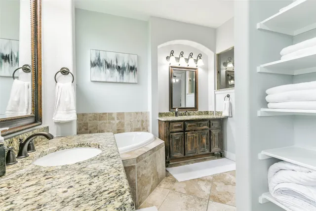 a large bathroom with a granite countertop sink a mirror and a
