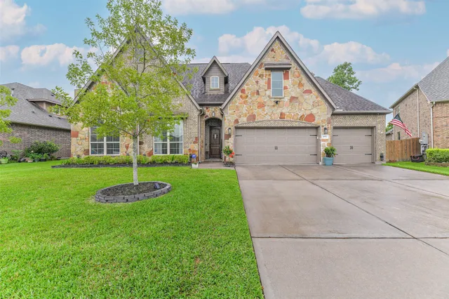 a front view of a house with a yard and potted plants