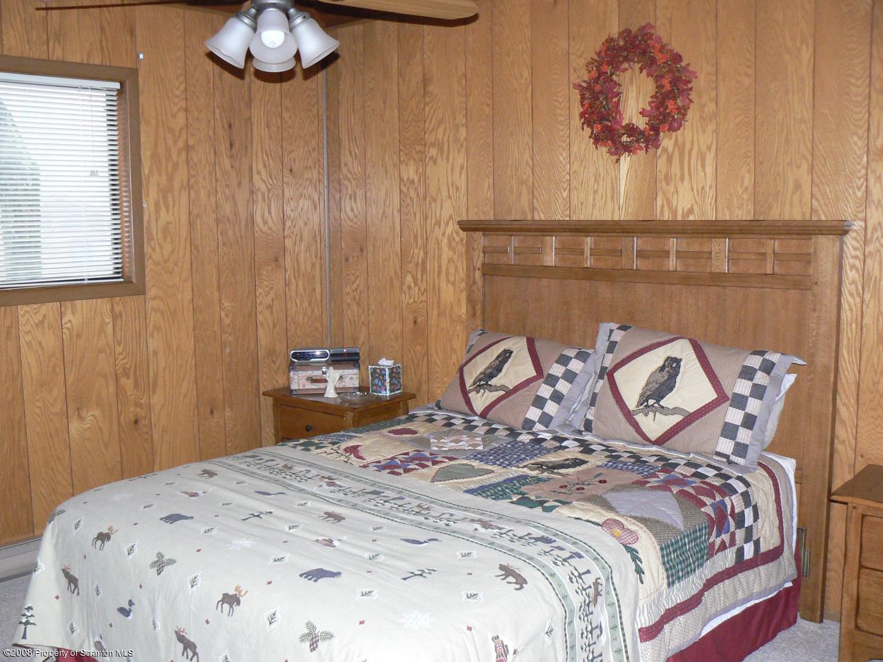 3198 Northgate Road Lake Ariel, PA 18436 - Photo 10 of 17 a bedroom with a bed and a chandelier