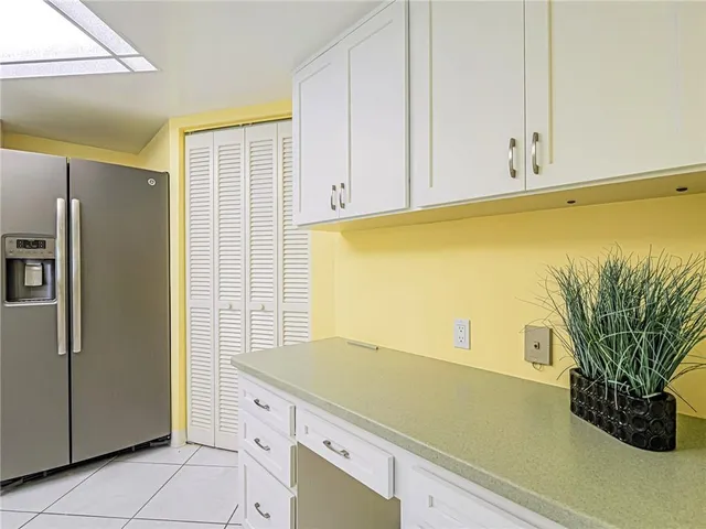 a kitchen with white cabinets and white appliances