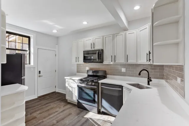 a kitchen with granite countertop a sink stainless steel appliances and cabinets