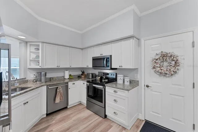 a kitchen with a sink a refrigerator and cabinets