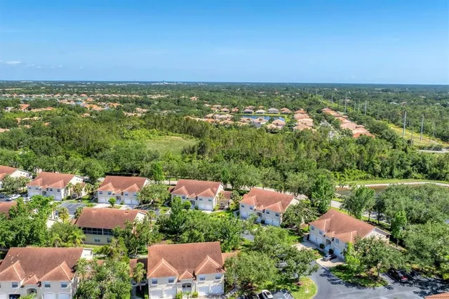 an aerial view of residential houses with outdoor space and trees