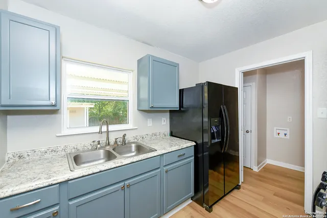 a kitchen with a refrigerator sink and cabinets
