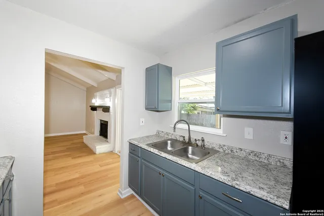 a kitchen with sink and mirror