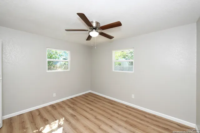 a view of empty room with wooden floor