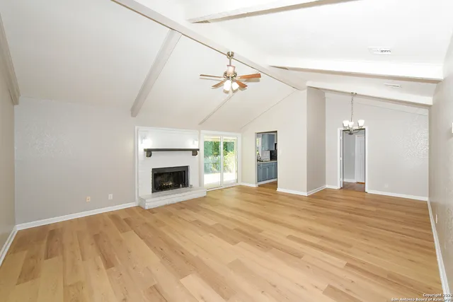 a view of an empty room with a fireplace and a window