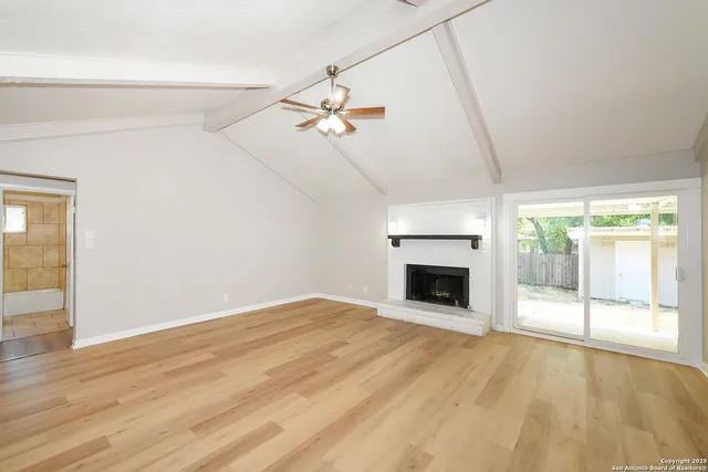 a view of empty room with fireplace and fan