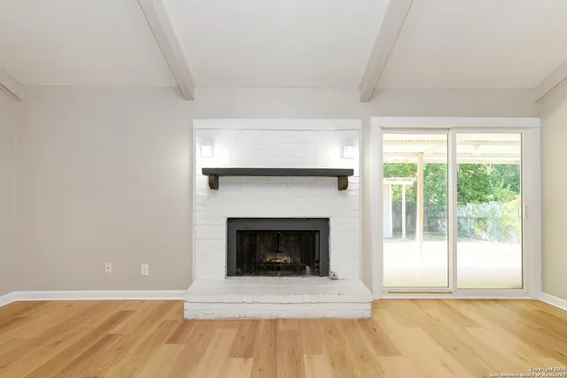 a living room with a fireplace and a floor to ceiling window