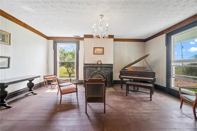 a living room with furniture a piano and a fireplace