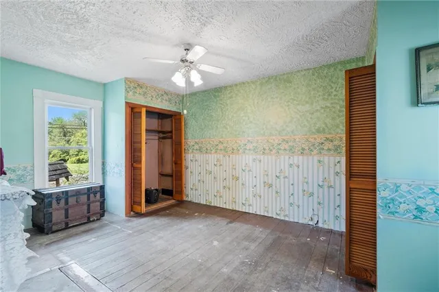 a view of an empty room with window and cabinet