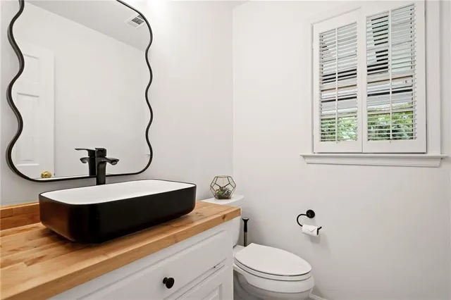 a bathroom with a sink a toilet and a mirror
