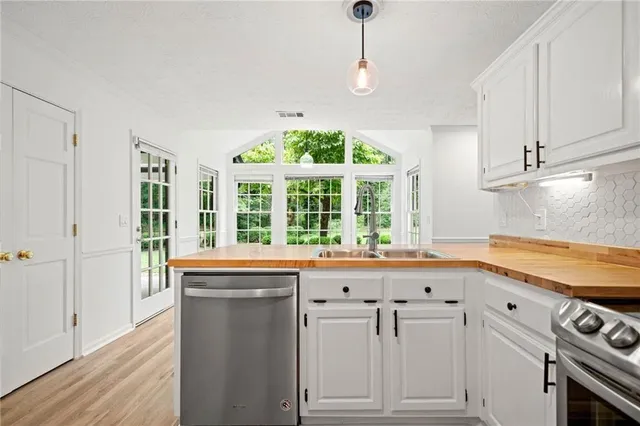 a kitchen with granite countertop white cabinets and window