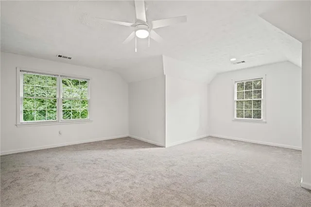 en empty room with windows and chandelier fan