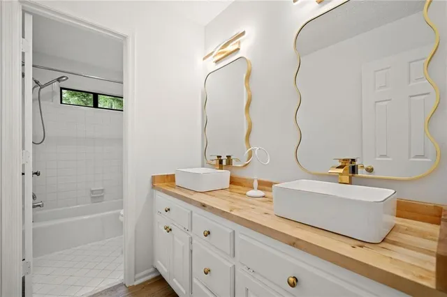 a bathroom with a tub sink and mirror