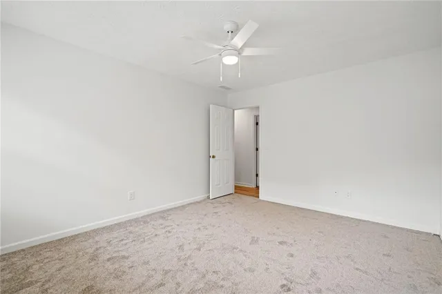 an empty room with a ceiling fan and hardwood floor