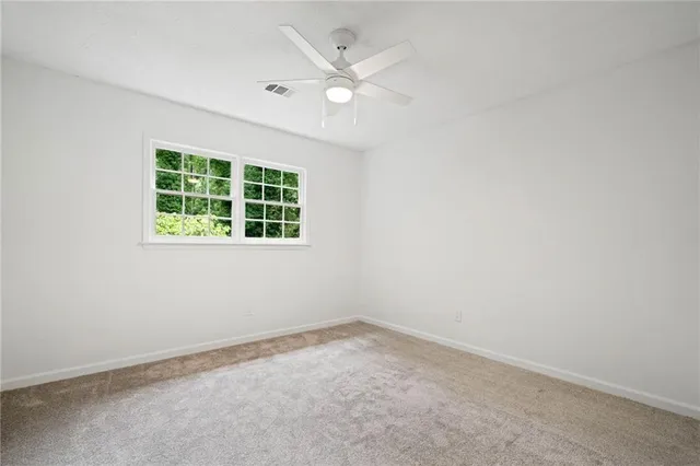 an empty room with a window and a ceiling fan