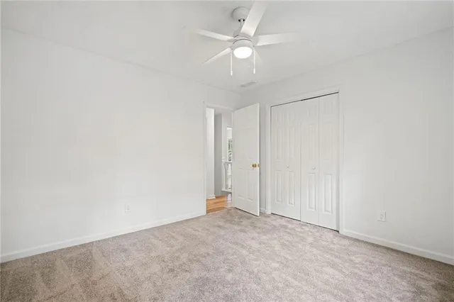 an empty room with a ceiling fan and a window