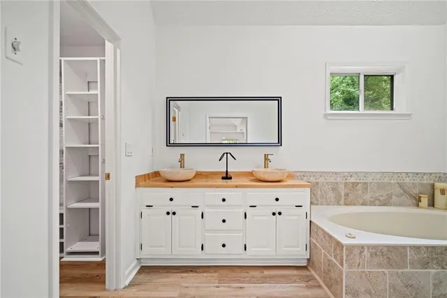 a bathroom with a tub a sink and a window