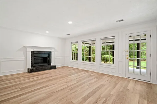 a view of a livingroom with a fireplace window and a wooden floor