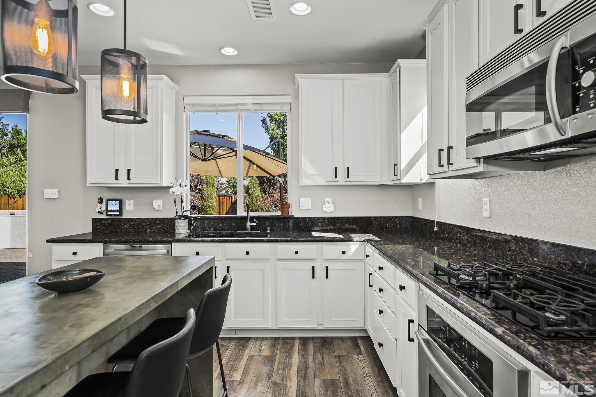 375 Sondrio Way Reno, NV 89521 - Photo 11 of 36 a kitchen with granite countertop a sink stove and cabinets