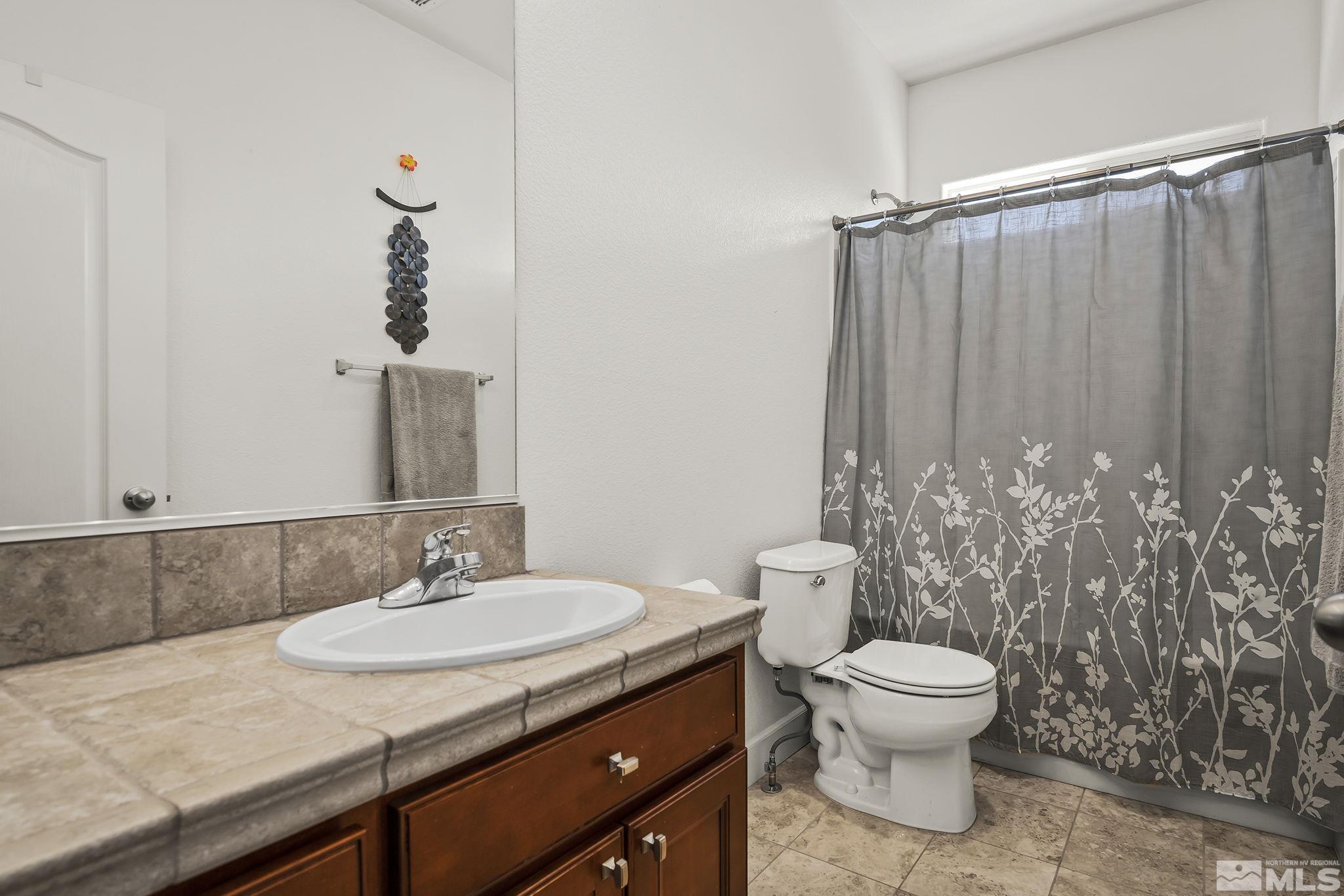 375 Sondrio Way Reno, NV 89521 - Photo 26 of 36 a bathroom with a granite countertop sink and a toilet