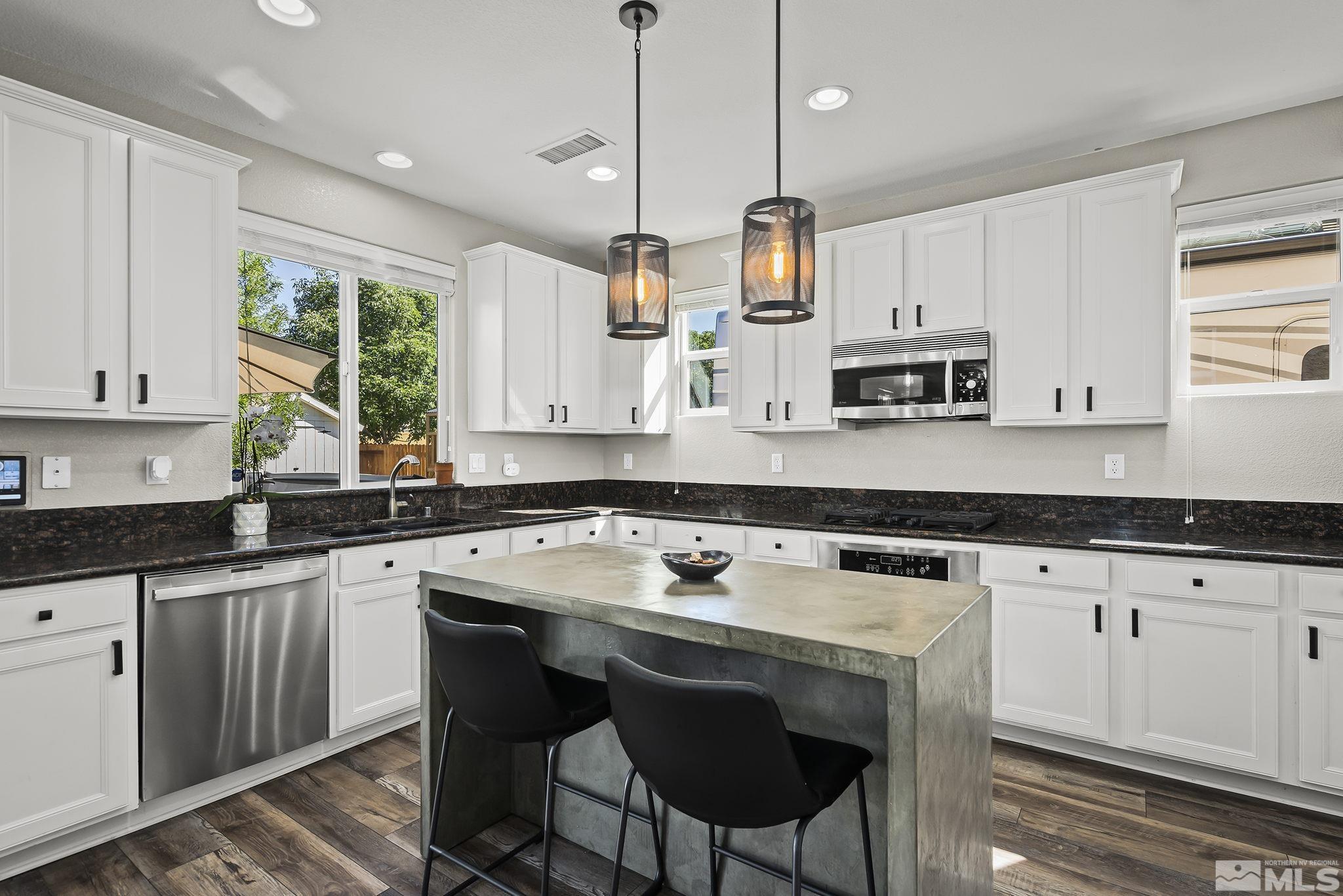 375 Sondrio Way Reno, NV 89521 - Photo 8 of 36 a kitchen with stainless steel appliances granite countertop a stove a sink a microwave a refrigerator and white cabinets