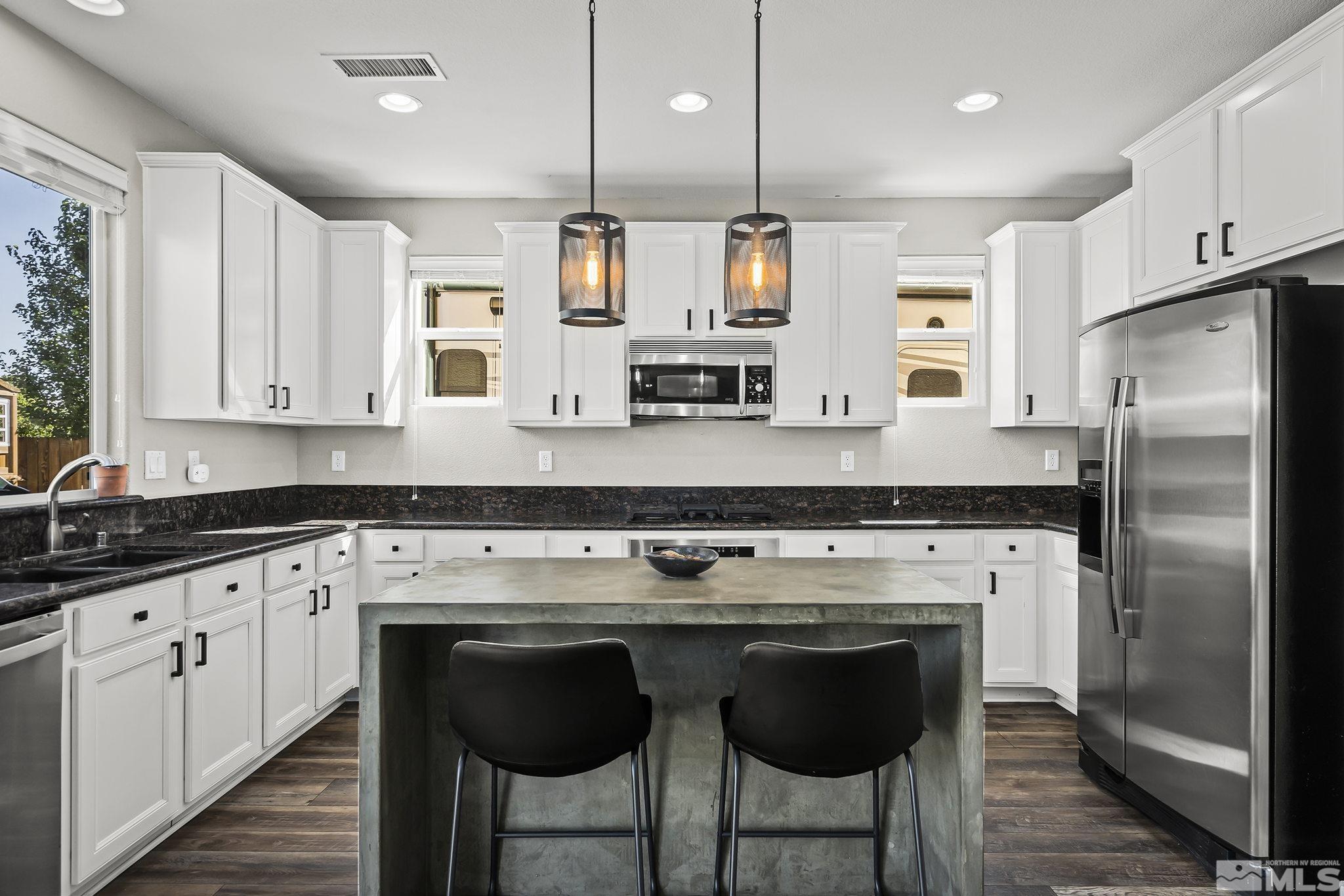 375 Sondrio Way Reno, NV 89521 - Photo 9 of 36 a kitchen with stainless steel appliances granite countertop a stove a sink and a refrigerator
