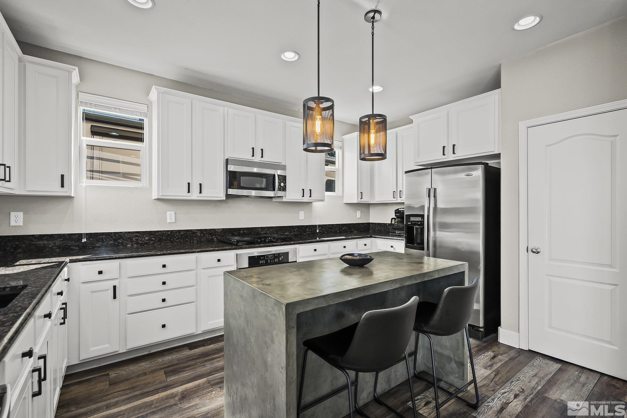 375 Sondrio Way Reno, NV 89521 - Photo 10 of 36 a kitchen with stainless steel appliances granite countertop a white cabinets and a stove