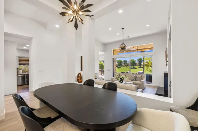 a kitchen with a dining table chairs and refrigerator