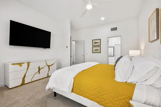 a bedroom with a large bed and a chandelier