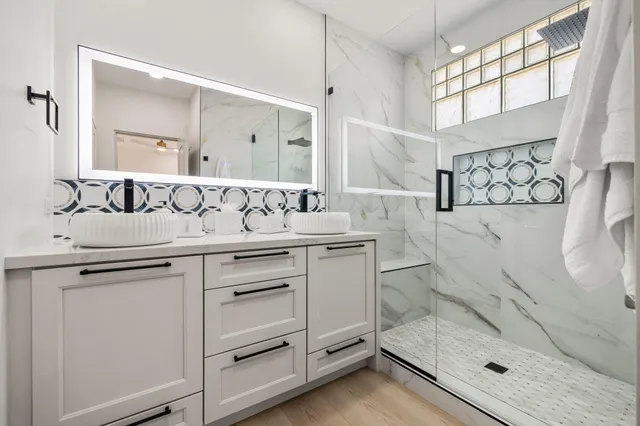 a bathroom with a granite countertop sink mirror and shower