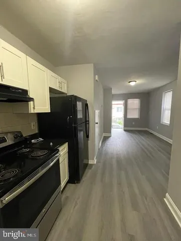 a kitchen with granite countertop a refrigerator stove and sink