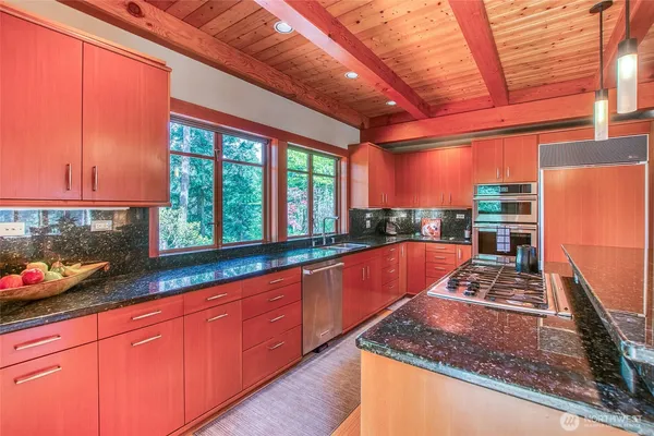 a kitchen with stainless steel appliances granite countertop a sink stove and cabinets