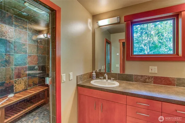 a bathroom with a granite countertop sink and a mirror