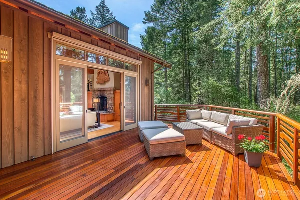 a balcony with wooden floor and outdoor seating
