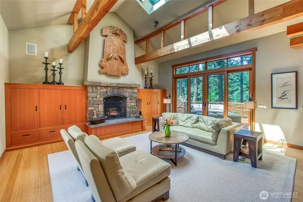 a living room with furniture a fireplace and a floor to ceiling window