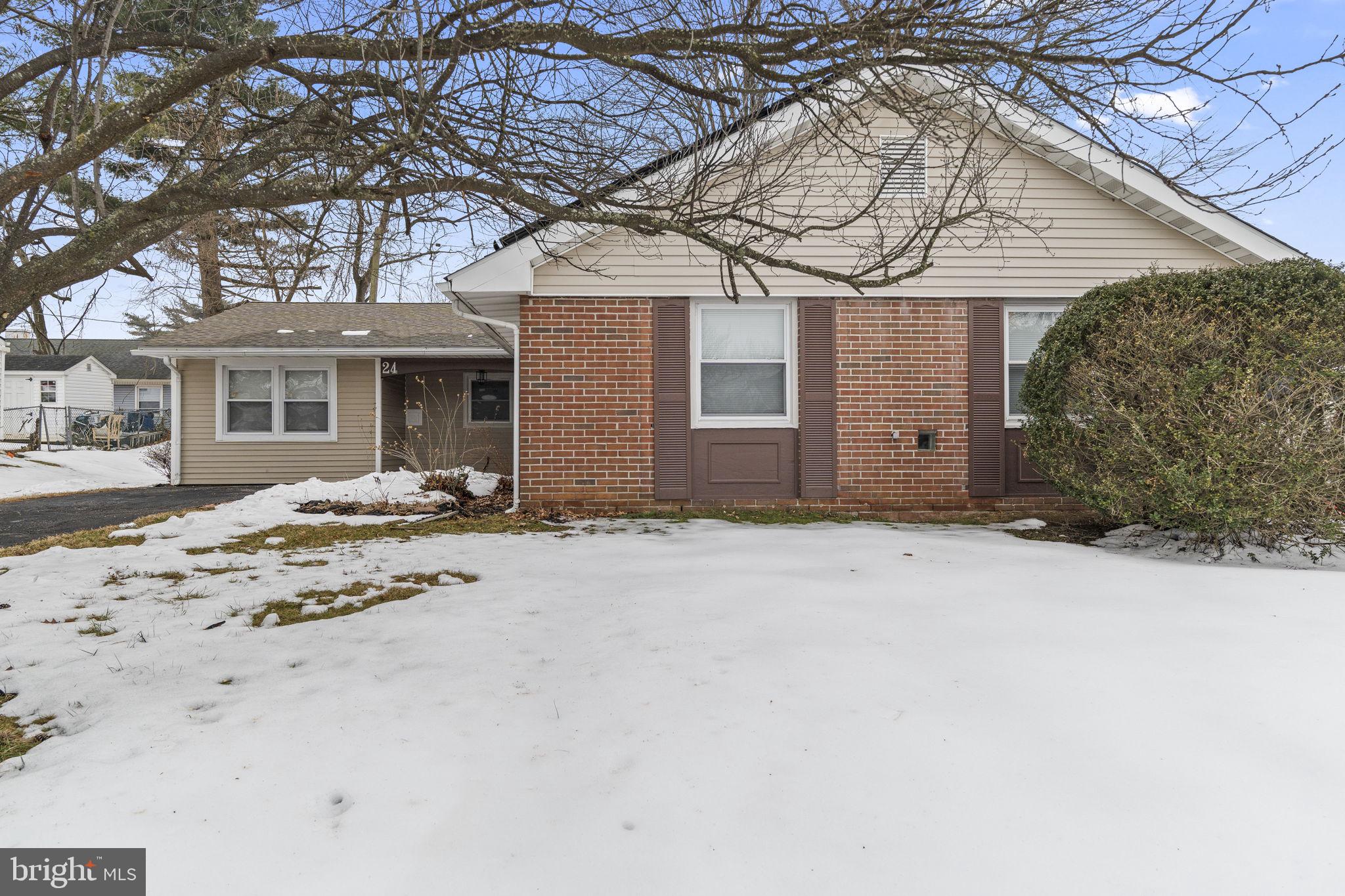 a front view of a house with a yard covered in snow