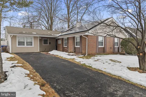 a front view of a house with a yard covered in snow