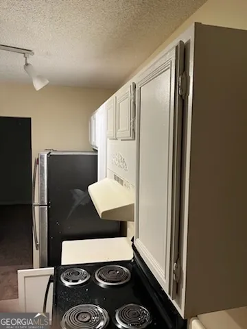 a view of a room with a hanging light and kitchen