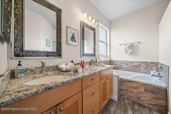 a bathroom with a granite countertop sink double vanity and mirror