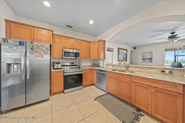 a large kitchen with stainless steel appliances granite countertop a refrigerator and a sink