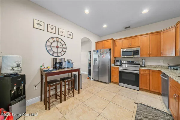 a kitchen with stainless steel appliances granite countertop a refrigerator and a stove top oven