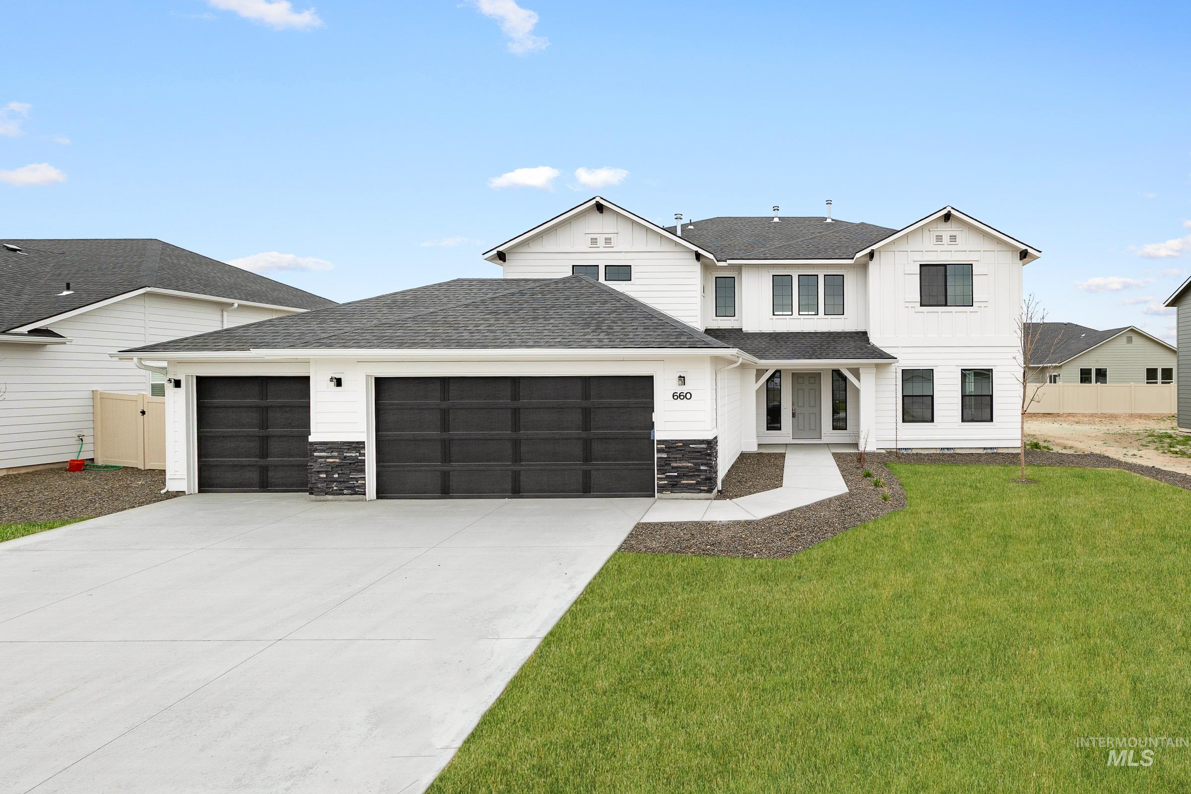 660 West Striped Owl Street Kuna, ID 83634 - Photo 1 of 1 View of front facade with a shingled roof, an attached garage, driveway, board and batten siding, and stone siding