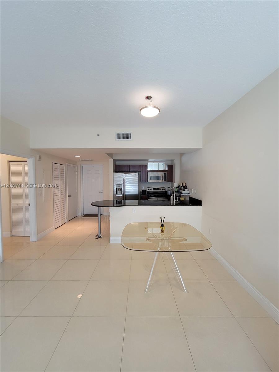 7290 Southwest 90th Street, Unit 403 Miami, FL 33156 - Photo 8 of 18 a room with kitchen island stainless steel appliances sink cabinets and window
