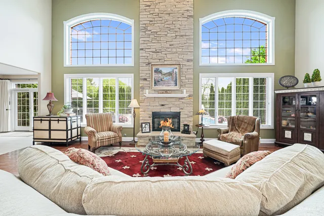 a living room with furniture fireplace and floor to ceiling windows
