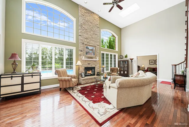 a living room with furniture large window and wooden floor