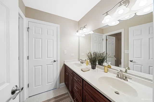 a bathroom with double vanity sinks and a mirror