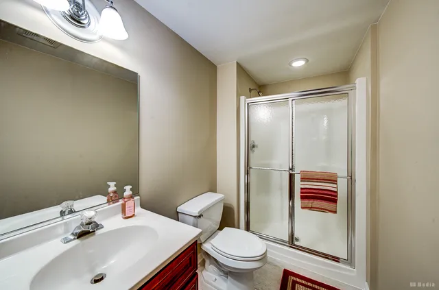 a bathroom with a sink a toilet and shower